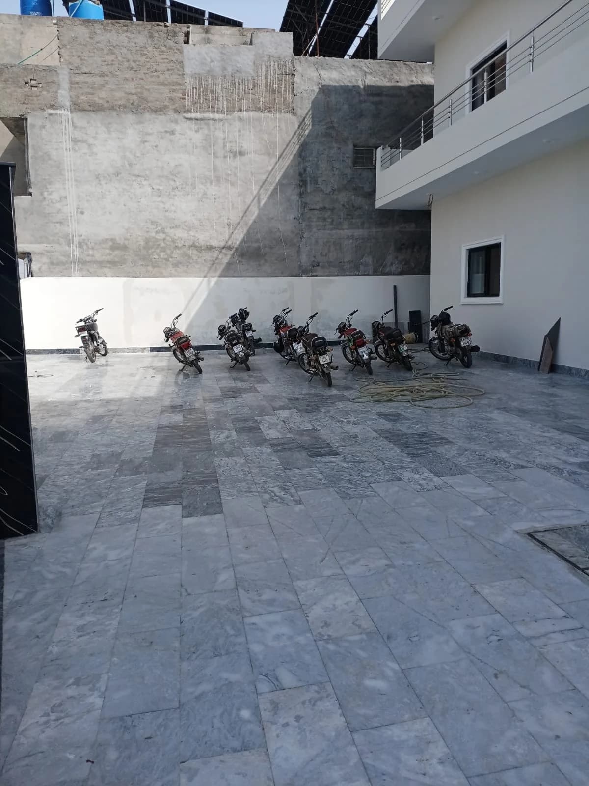 Motorcycles parked in the paved courtyard beside the building