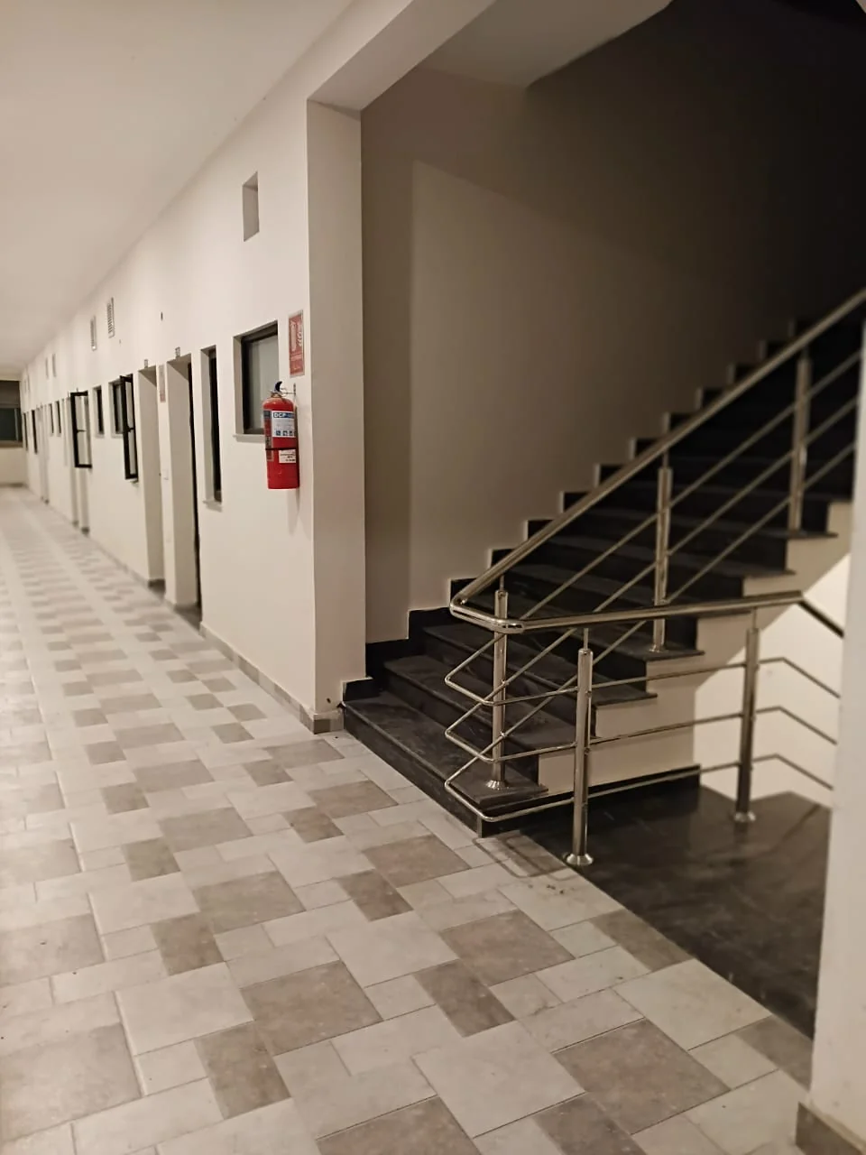 Staircase landing opening onto the shared tiled corridor