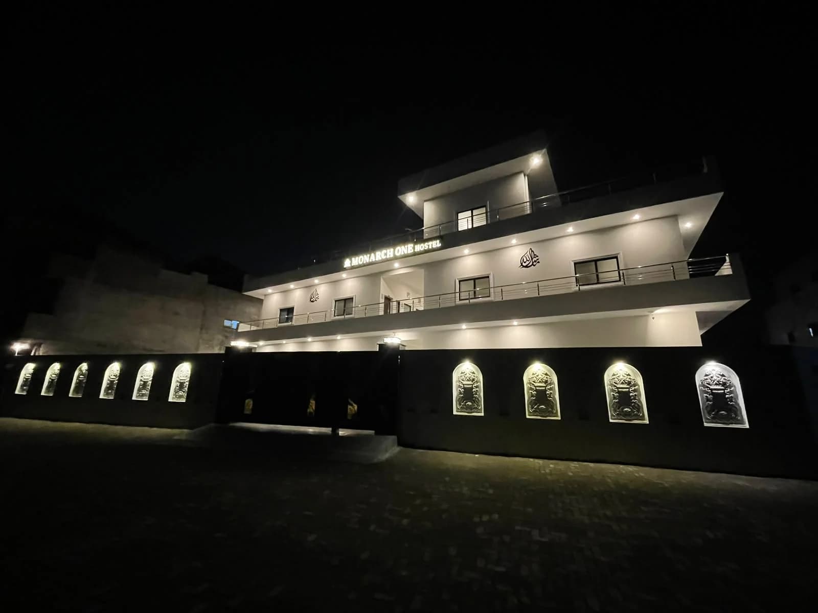 Side view of Monarch One's illuminated facade and gate at night