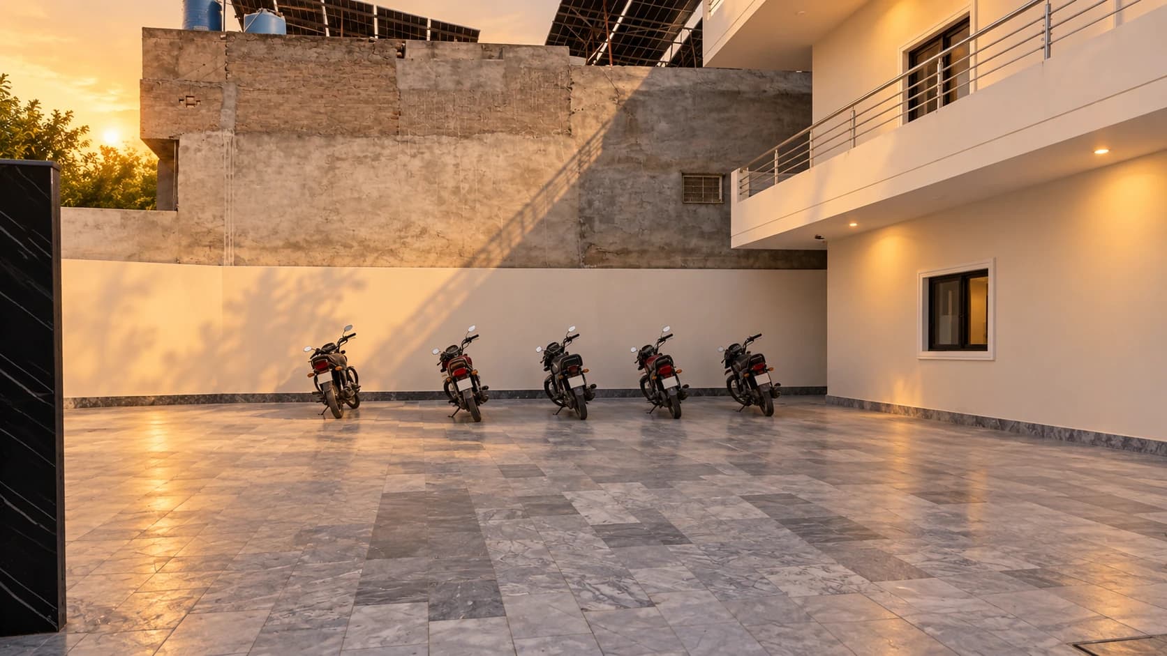 Motorcycle parking in the stone courtyard beside the white residence building