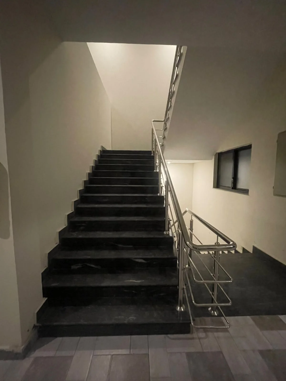 Stone staircase and stainless-steel handrail inside the residence
