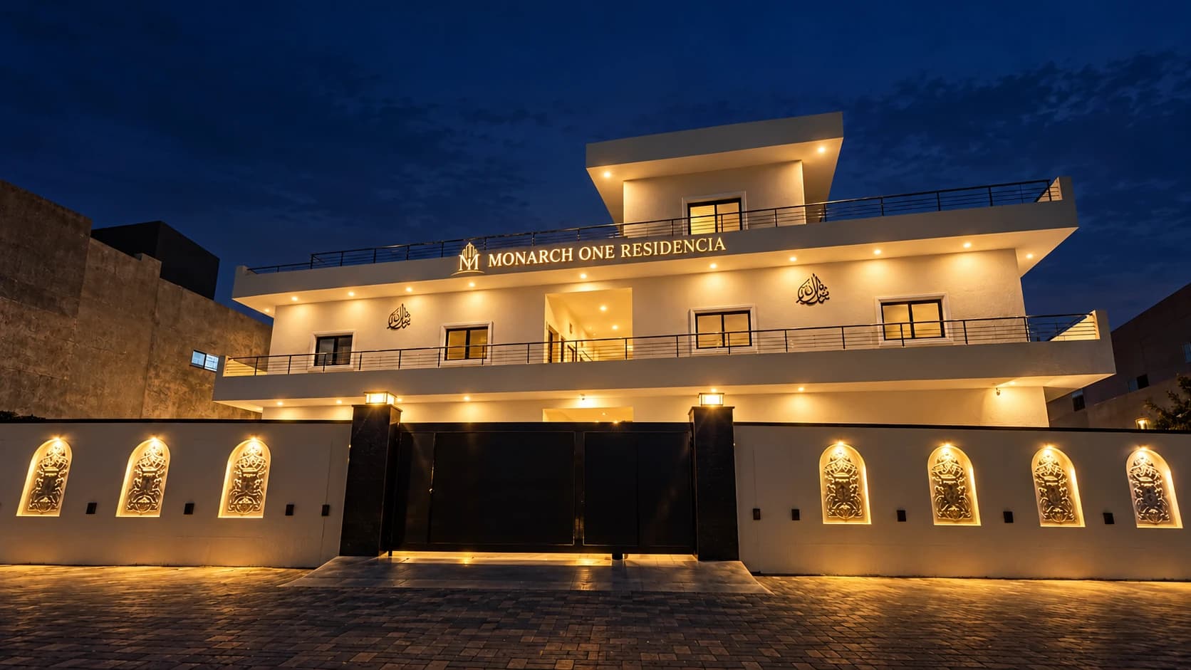 A front-on evening view of the Monarch One building and its illuminated sign